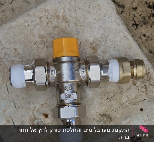 שסתום מתכת עם חיבורים על רקע אבן